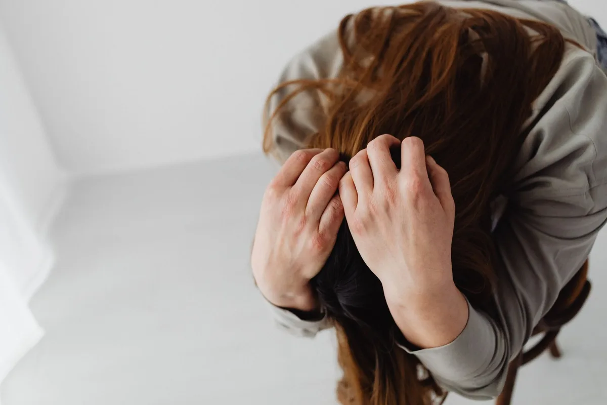 Personne assise seule, l'air fatiguée et préoccupée, illustrant les signes de dépression