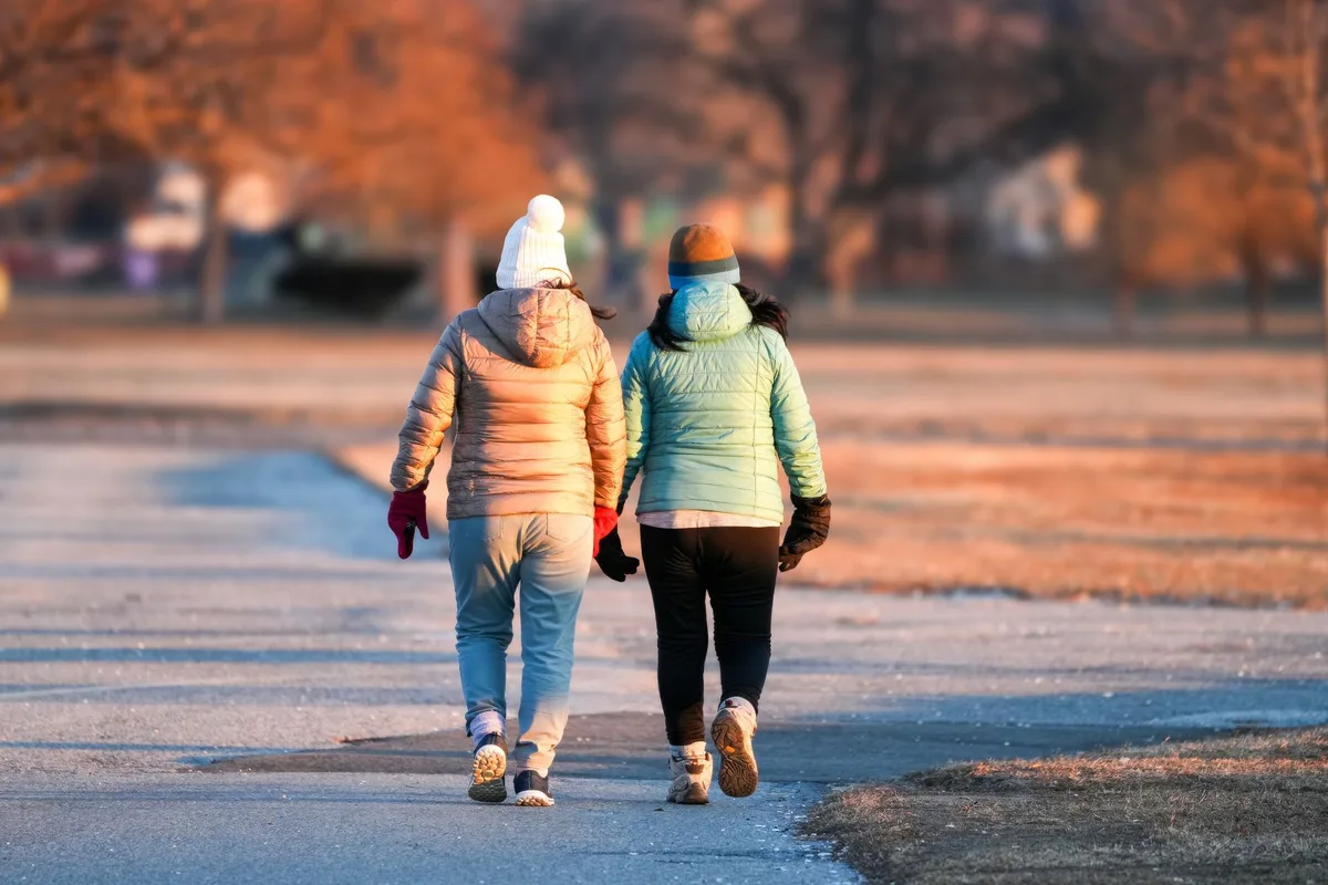 Deux personnes marchant ensemble en plein air dans une atmosphère de soutien mutuel