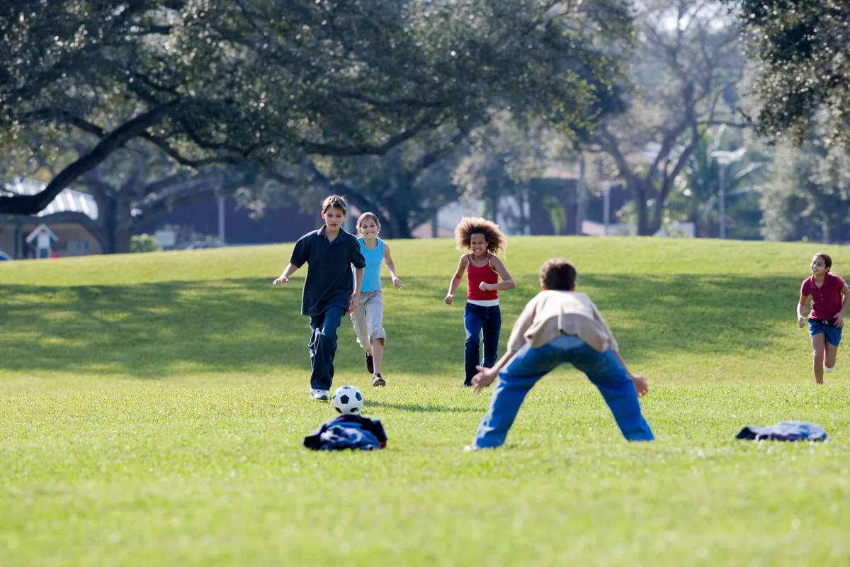 Enfants jouant activement dehors, canalisant leur énergie par des jeux physiques supervisés.