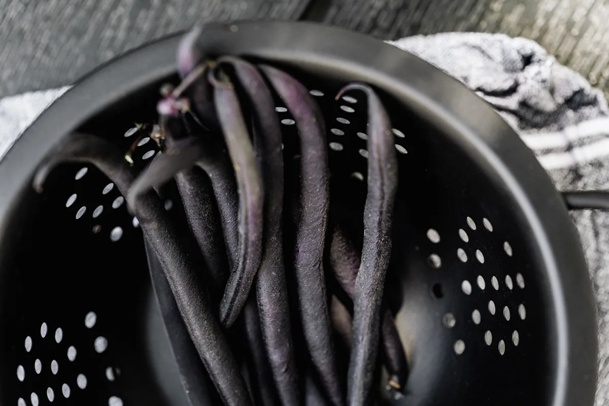 Haricots blancs en conserve rincés à l'eau dans une passoire