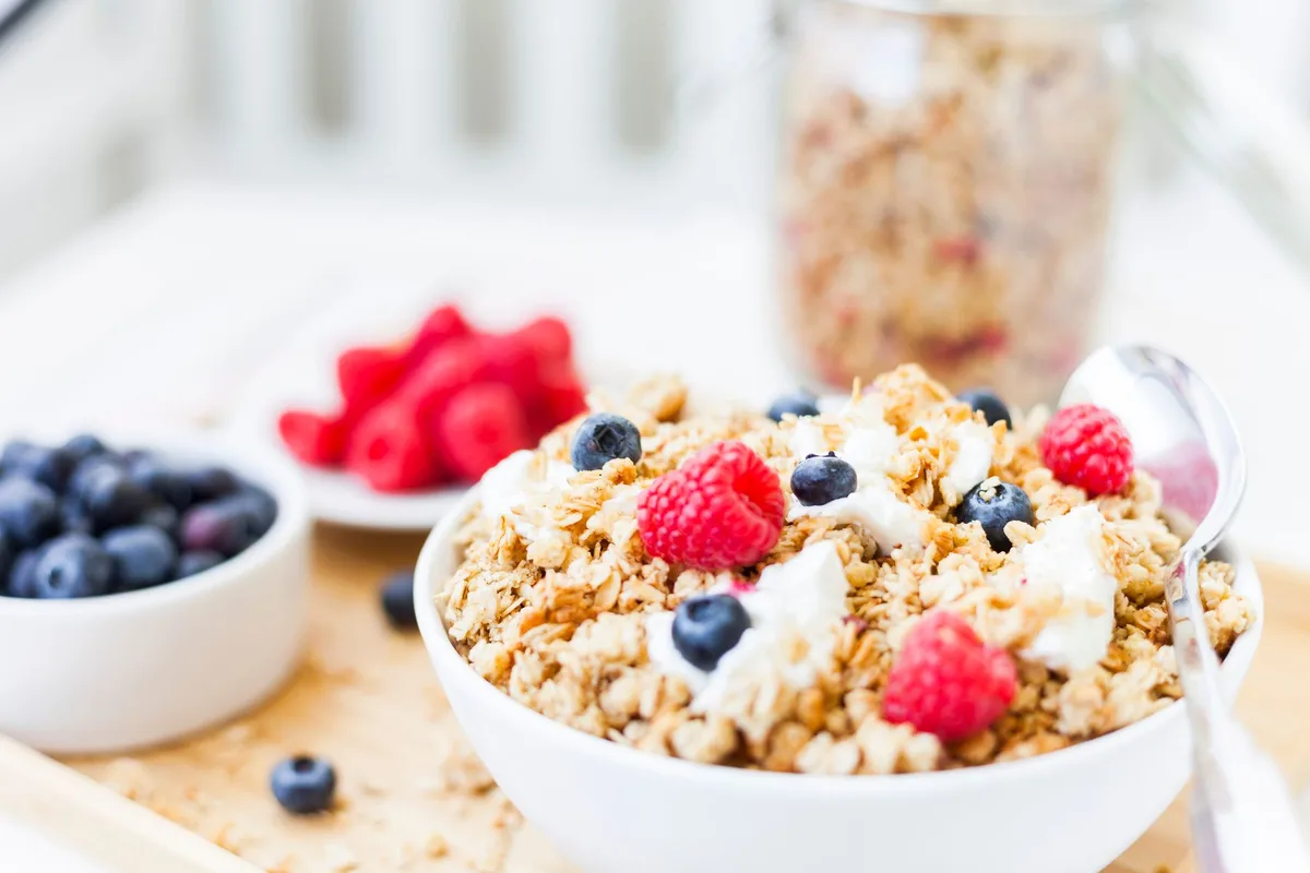 Bol de porridge garni de granola industriel sucré et de pâte à tartiner caloriques