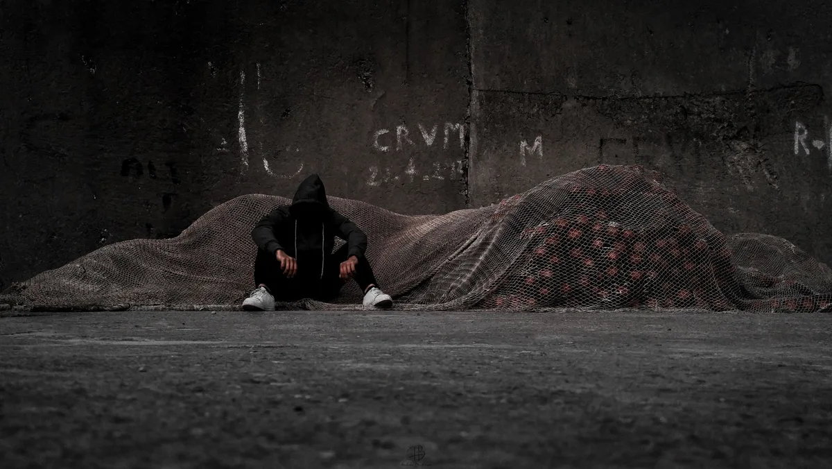 Personne assise isolée, tournée vers l'intérieur, symbolisant le repli social.