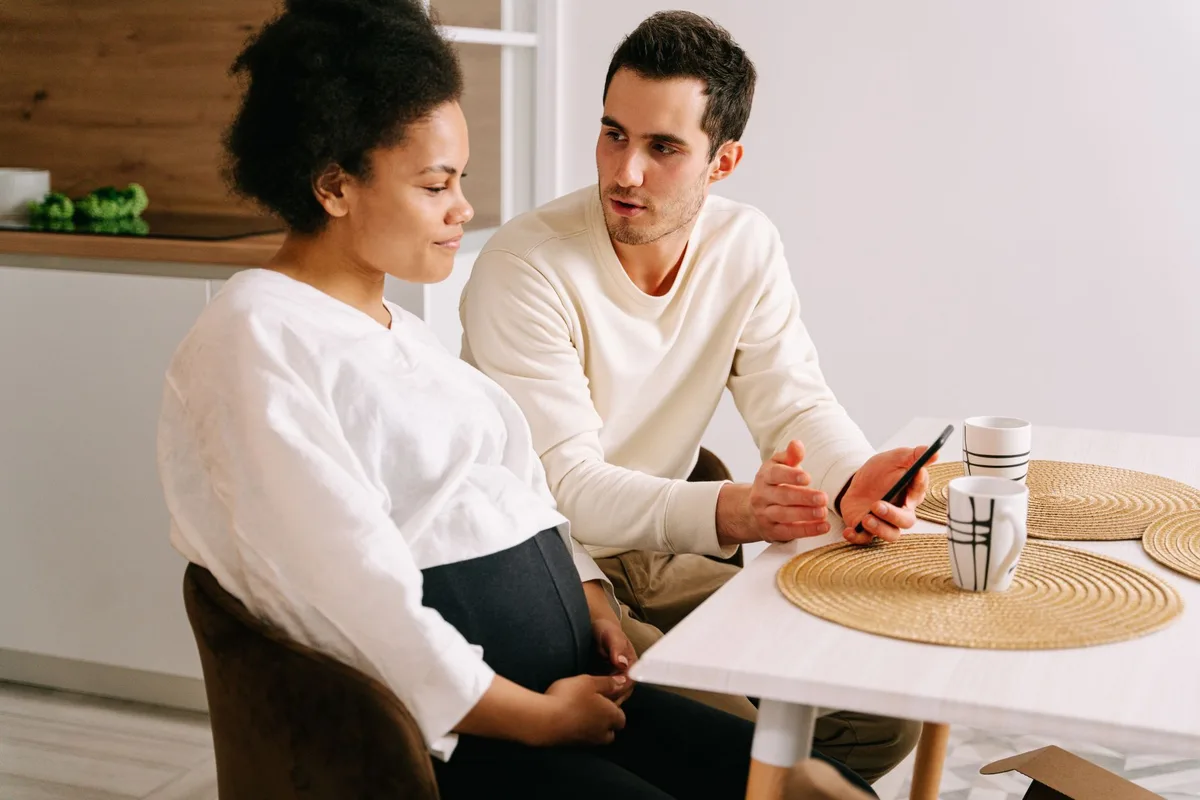 Un couple en conversation ouverte, discutant ensemble des préoccupations liées à la grossesse