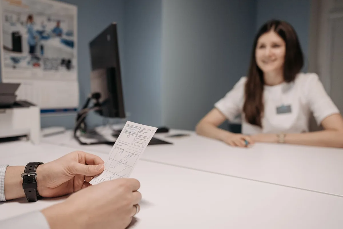 Mains tenant des documents médicaux et une échographie sur un bureau de consultation