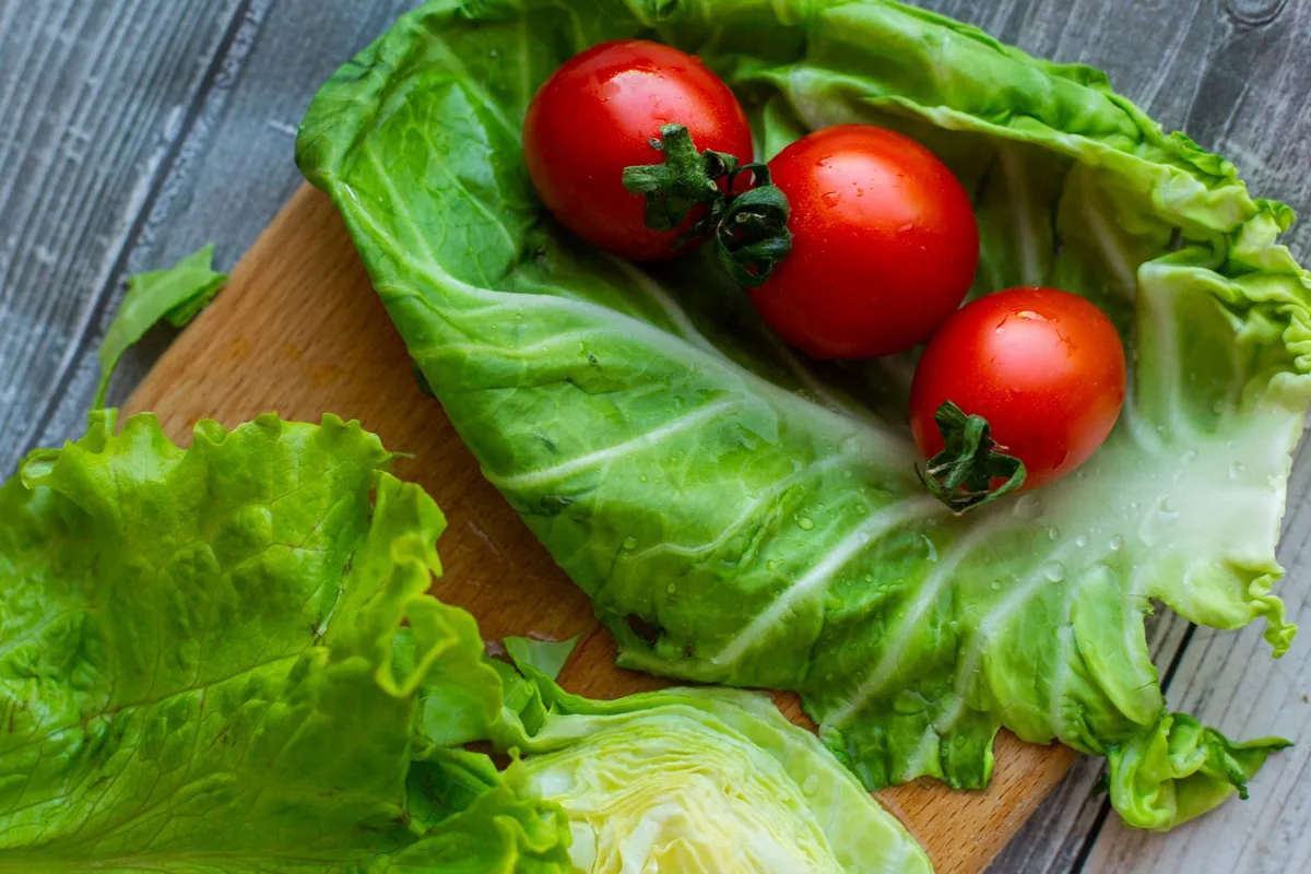Préparation d'une salade équilibrée avec légumes frais, légumineuses, poulet grillé et huile d'olive.