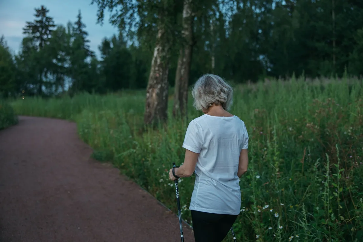 Femme marchant à allure régulière et modérée sur un sentier en plein air