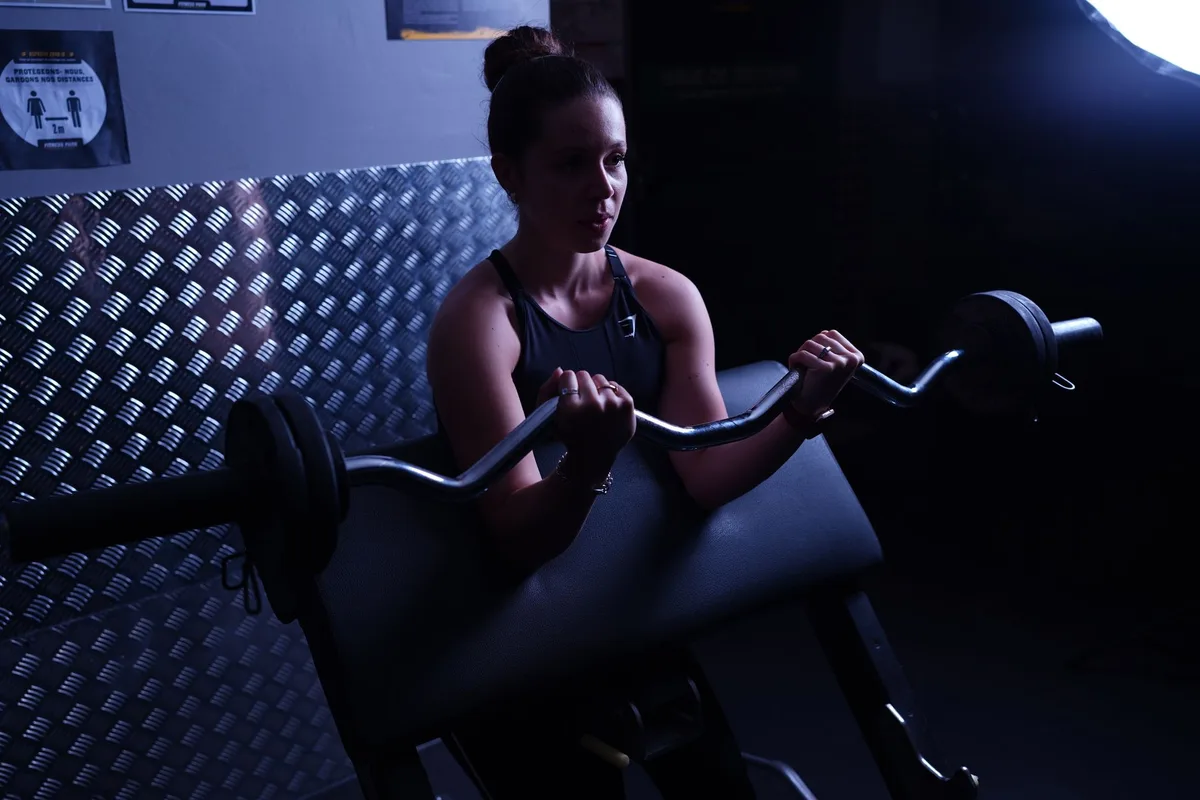 Femme effectuant un exercice de renforcement musculaire avec des poids