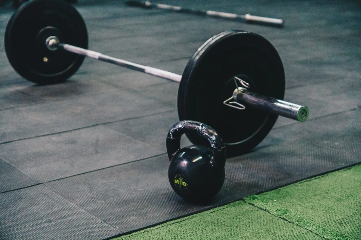 Séance d'entraînement en salle avec équipements de musculation et haltères