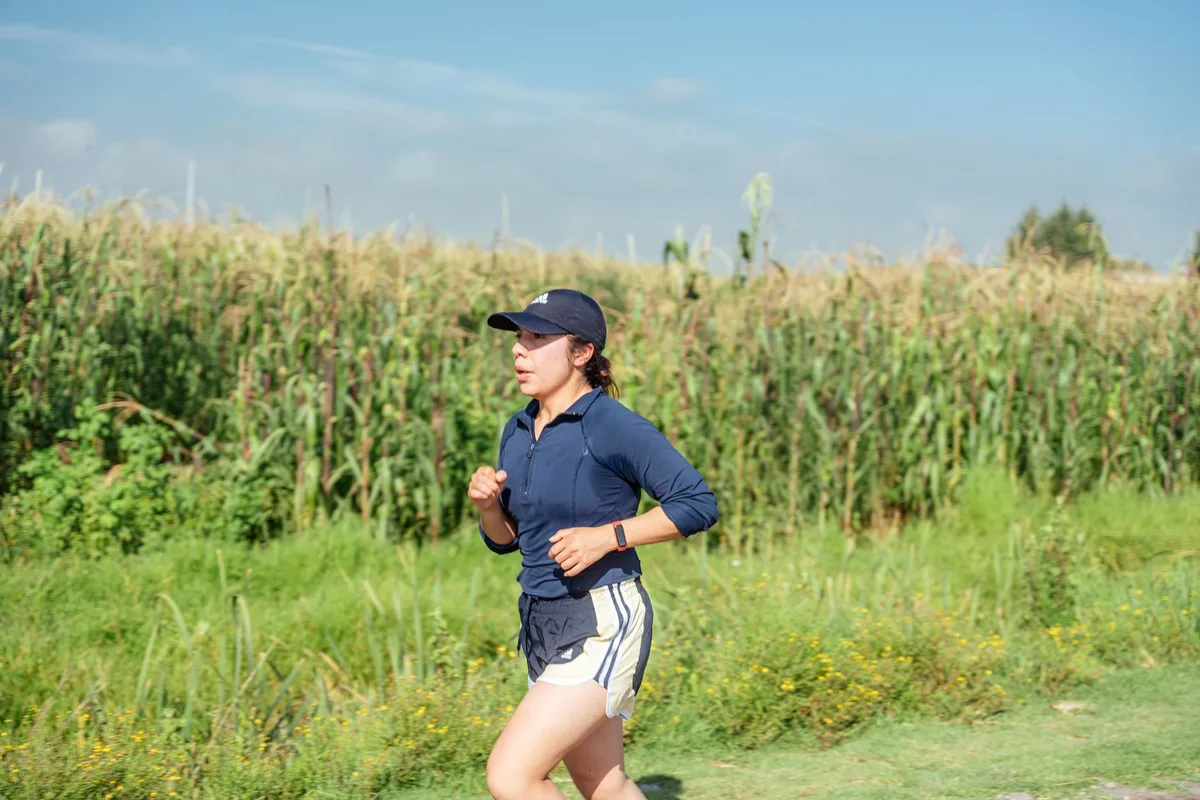 Femme marchant à allure rapide sur un chemin, illustrant l'effort cardiovasculaire de la marche soutenue.