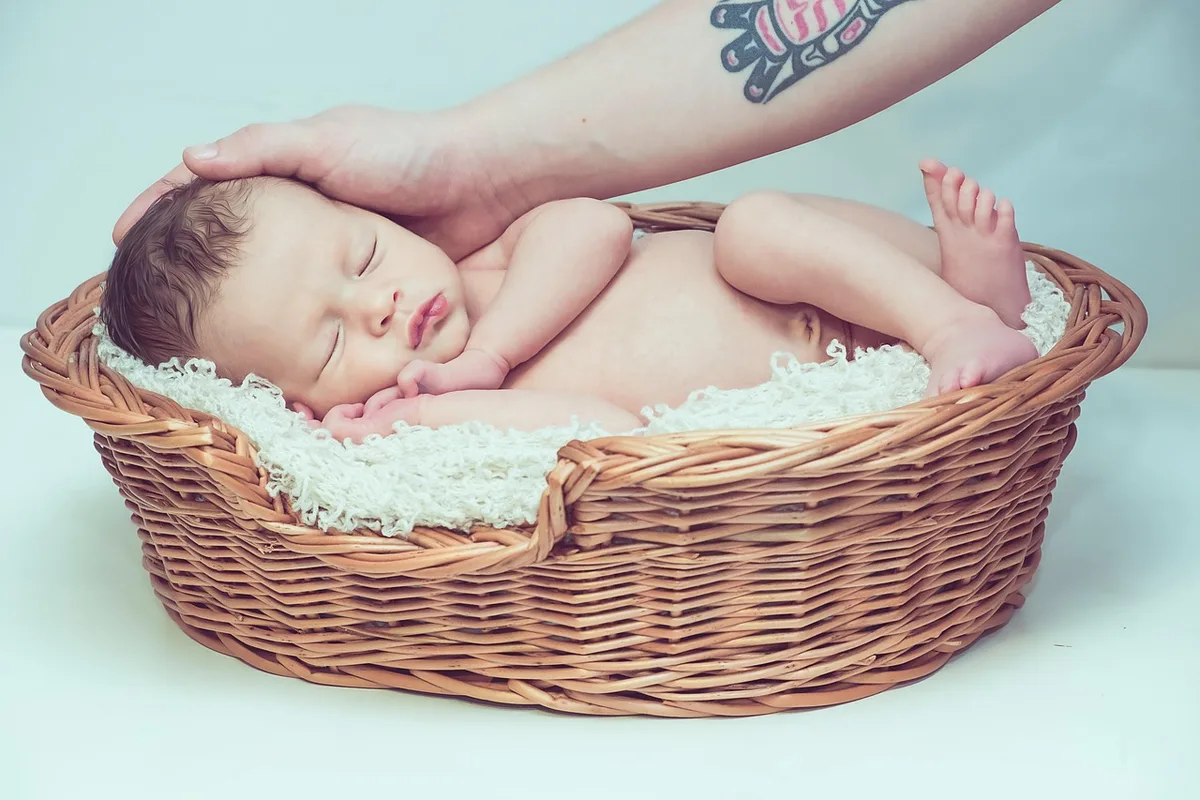 Mains tenant un bébé pendant une tétée, lumière du jour