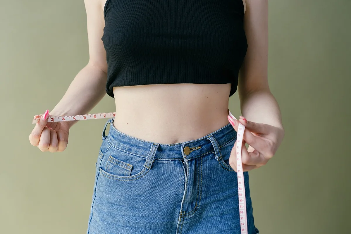 Mesure du tour de taille avec un mètre de couturière sur une silhouette