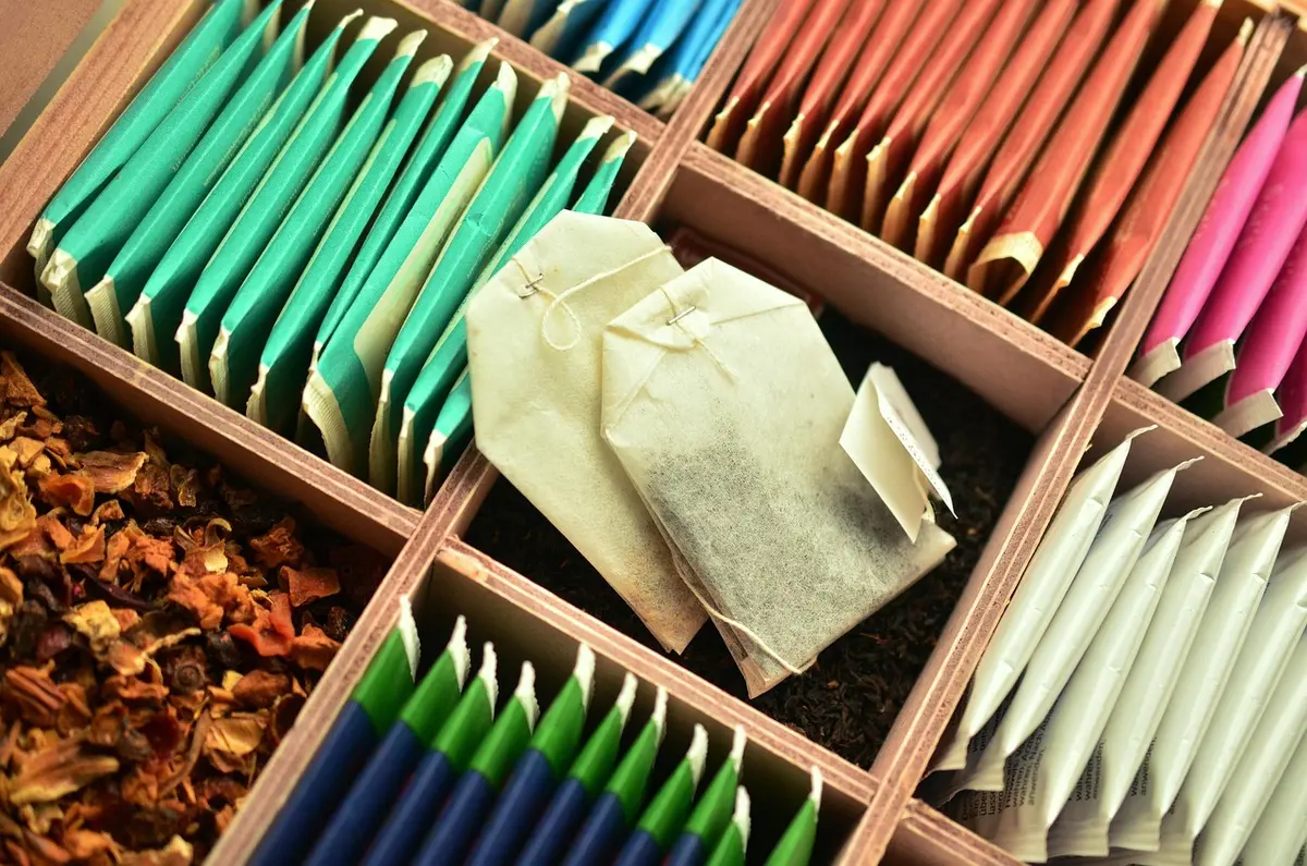 Tasse d'infusion de thym près d'un bol d'herbes sèches