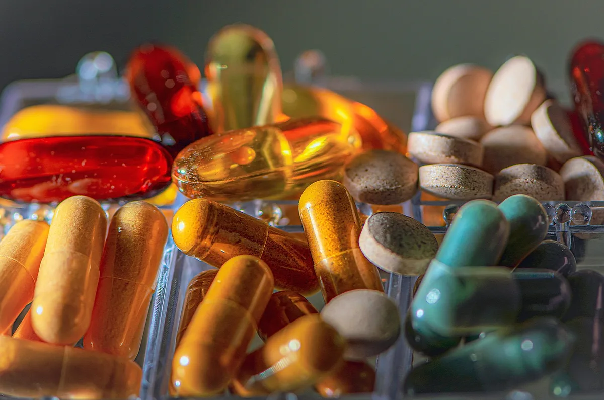 Médicaments et ordonnance sur une table évoquant causes médicamenteuses d'un écoulement