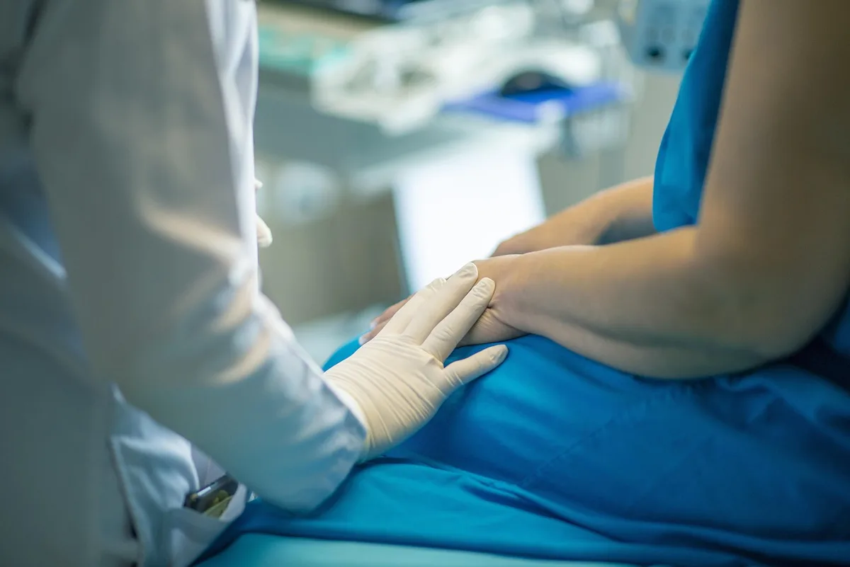 Personne en journée se tenant l'abdomen en consultation d'urgence