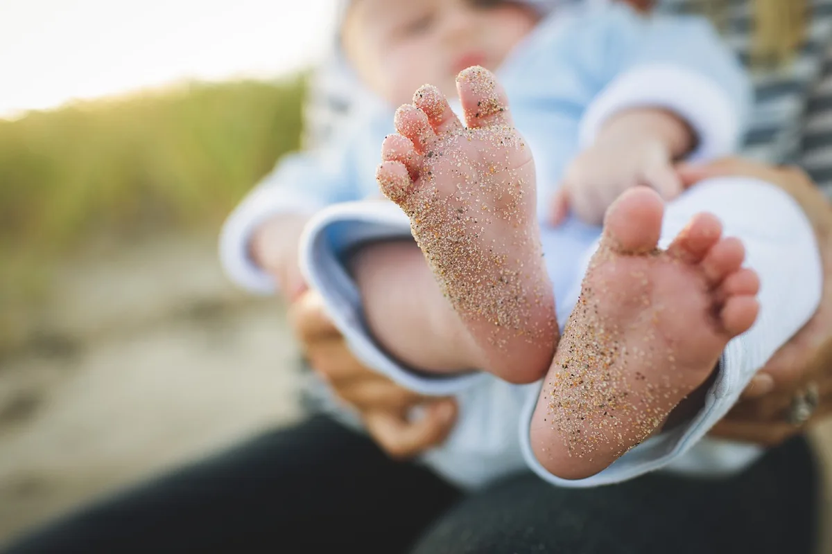 Parent qui sèche un enfant avec une serviette au bord de la piscine