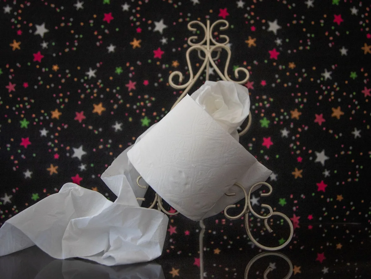 Papier toilette avec traces rouges sur un lavabo lumineux