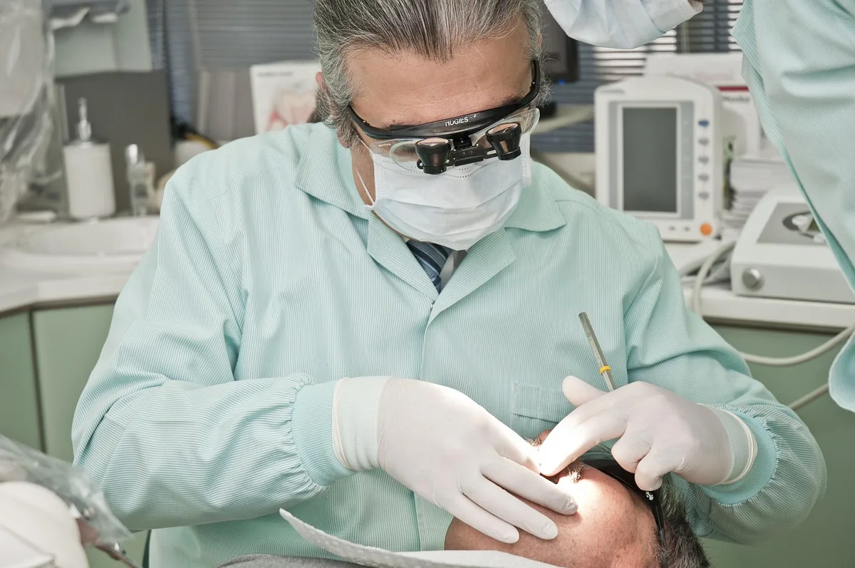 Mains appliquant une compresse chaude sur la paupière