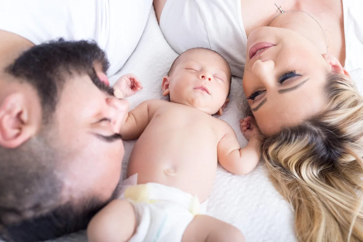 Parent calme guidant un enfant près du lit dans une chambre éclairée